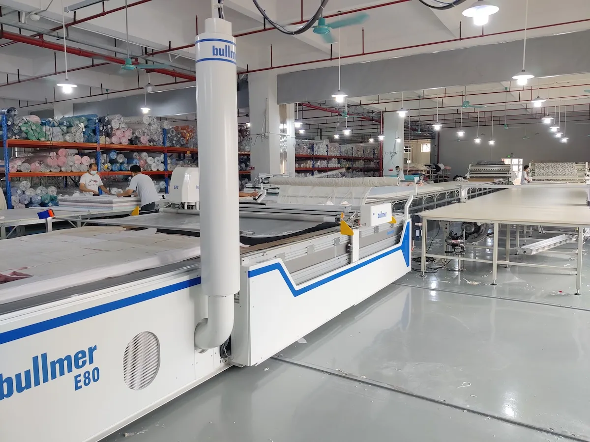 Automatic CNC cutting machine preparing layered fabric panels