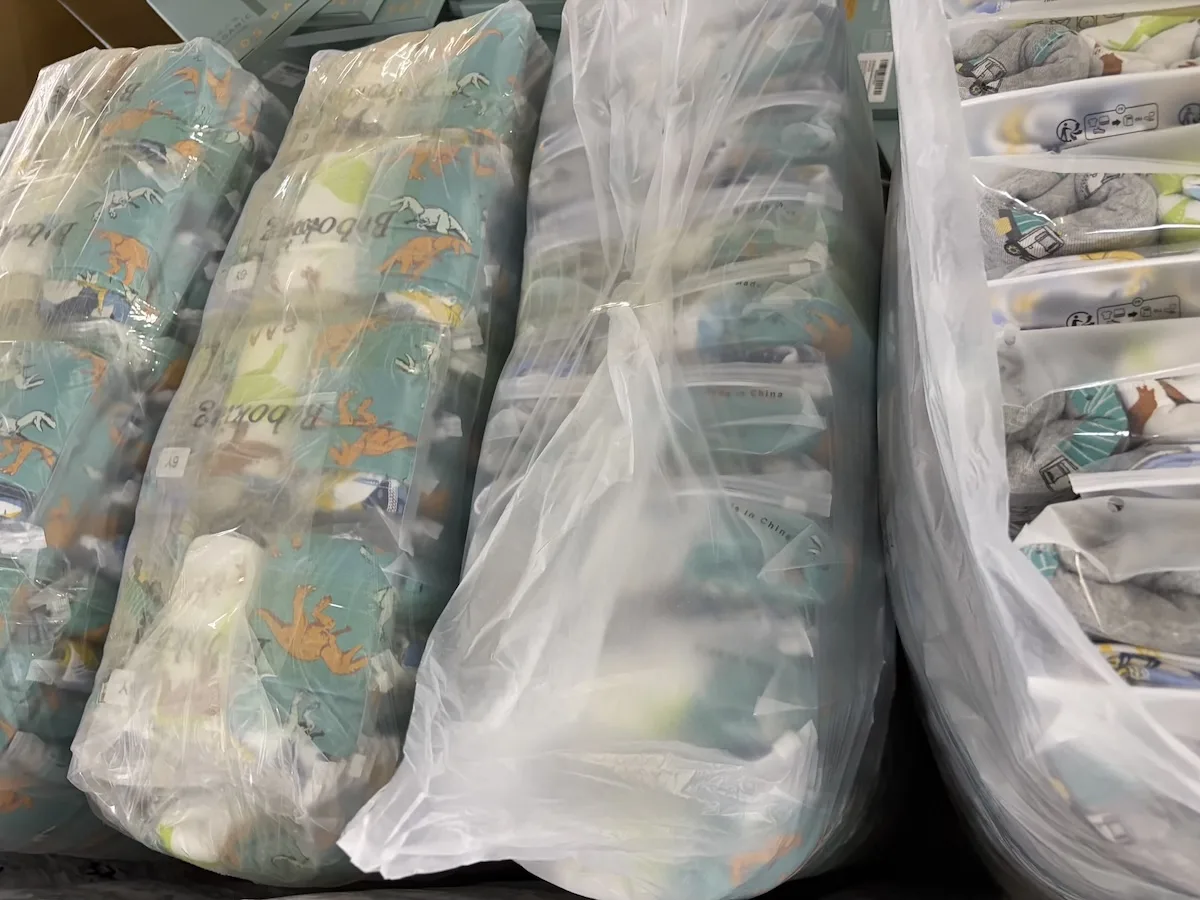 Rolls of patterned knit fabric on a warehouse shelf