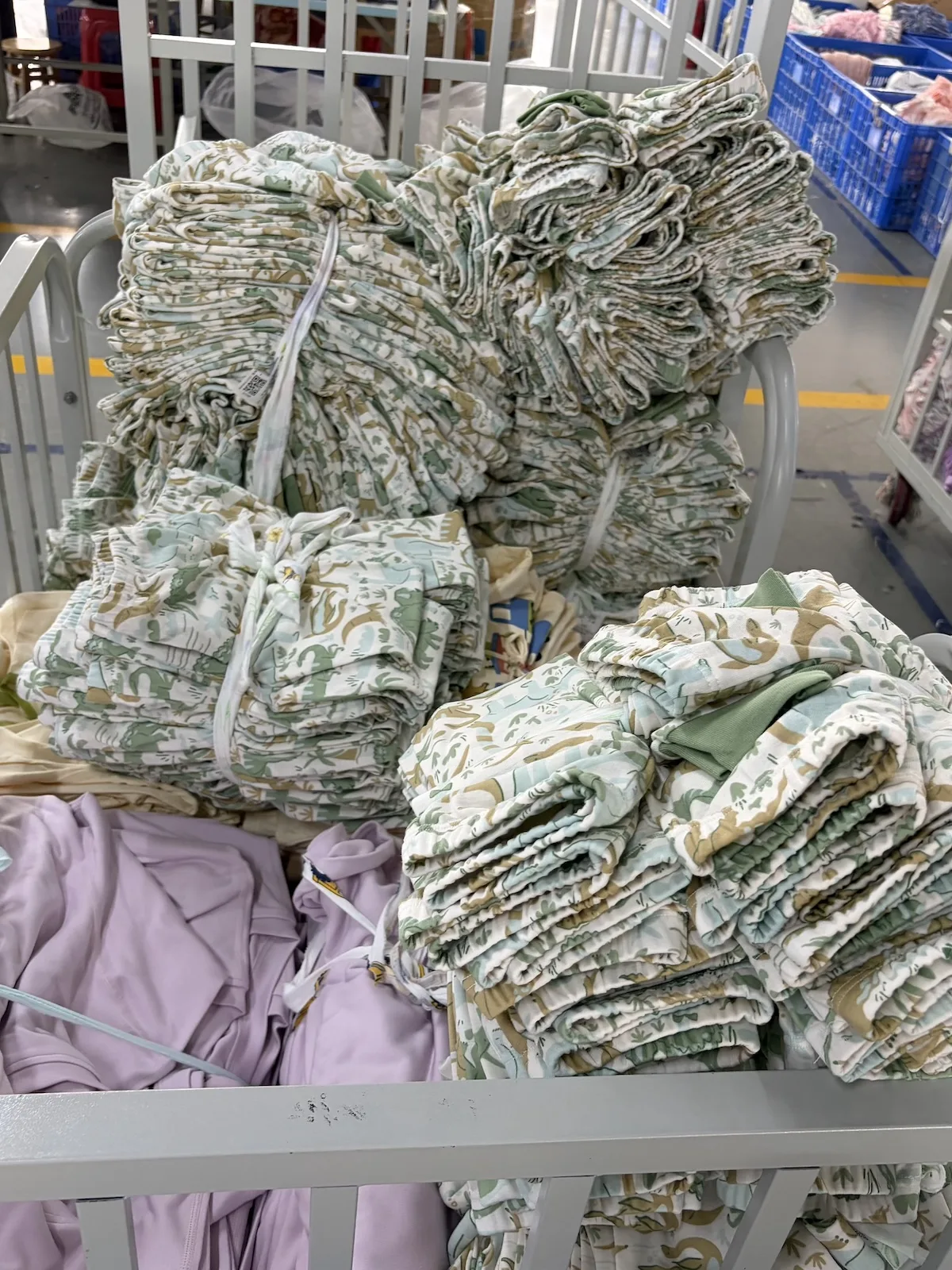 Stacked rolls of knitted fabric in a garment factory storage area