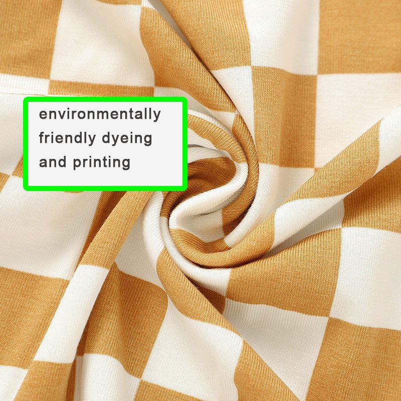 Close-up of mustard and white checkered bamboo viscose jersey fabric showing print and knit texture