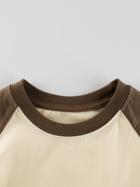 Close-up of double-stitched crew neck on kids blank cotton raglan t-shirt