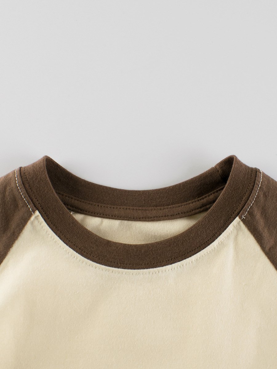 Close-up of double-stitched crew neck on kids blank cotton raglan t-shirt