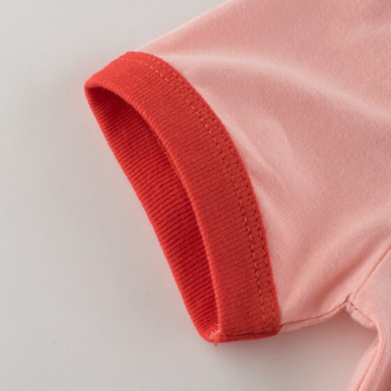 Close-up of red ribbed contrast sleeve cuff stitching on kids short sleeve t-shirt