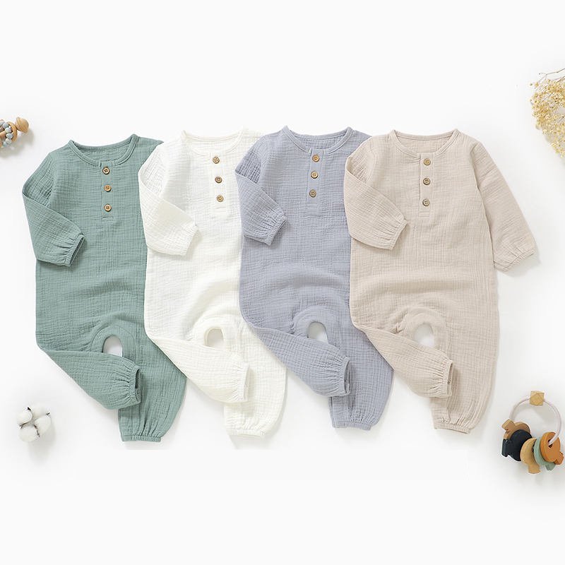Four color options of long sleeve muslin baby jumpsuits displayed flat