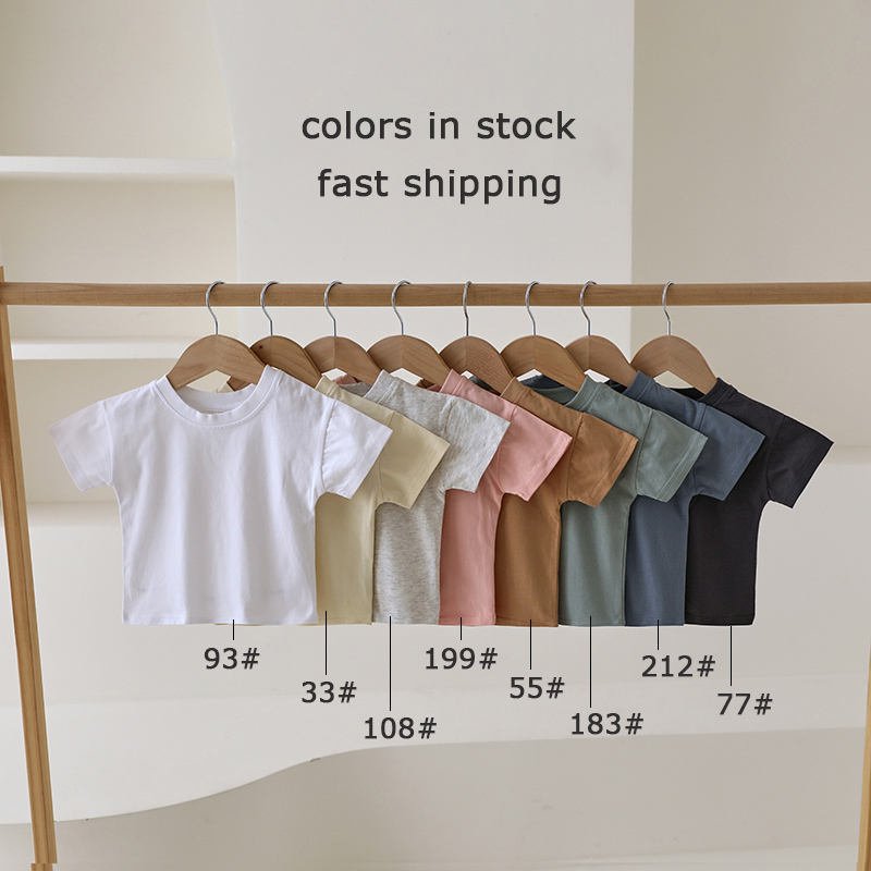 Organic cotton baby T-shirts displayed in eight in-stock colors on wooden hangers