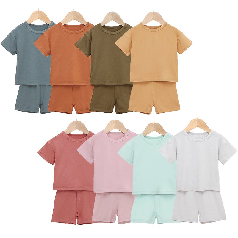 Wholesale bamboo baby pajama sets displayed in multiple solid colors for kidswear sourcing